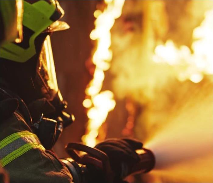 img src =”firefighter.jpg” alt = "a firefighter battling a fire with a water hose in hand” >